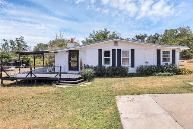 view of front of house featuring a front lawn and a deck