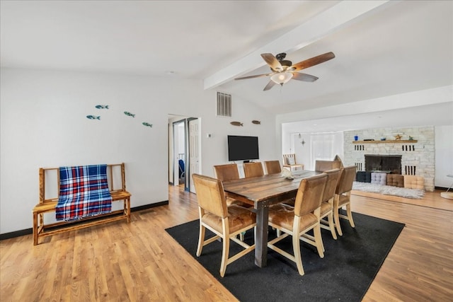 dining room with ceiling fan, vaulted ceiling with beams, and light hardwood / wood-style floors