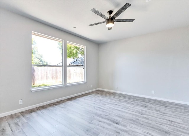 unfurnished room featuring light wood-type flooring, baseboards, and a ceiling fan