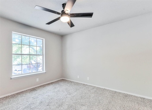 carpeted empty room featuring ceiling fan, a textured ceiling, and baseboards