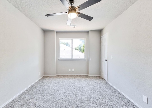 unfurnished room with a ceiling fan, baseboards, a textured ceiling, and light colored carpet