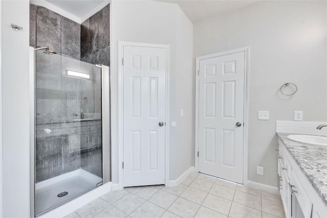 bathroom featuring a stall shower, tile patterned flooring, baseboards, and vanity