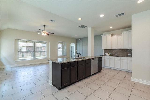 kitchen featuring arched walkways, light tile patterned flooring, a sink, visible vents, and stainless steel dishwasher