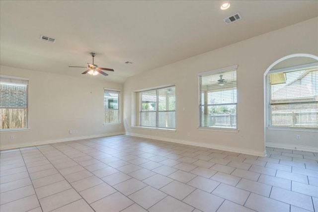 empty room with a healthy amount of sunlight, visible vents, and light tile patterned floors