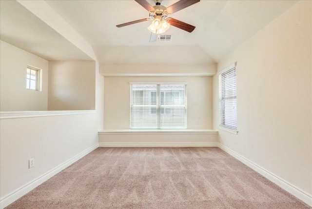 empty room with carpet floors, lofted ceiling, visible vents, and baseboards