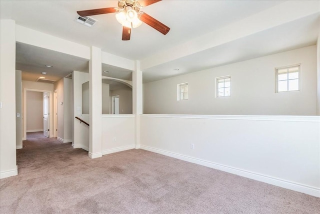 carpeted empty room featuring baseboards, visible vents, and ceiling fan