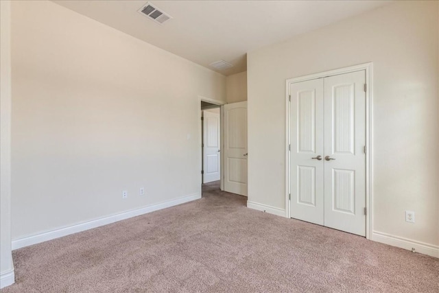 unfurnished bedroom with carpet floors, a closet, visible vents, and baseboards