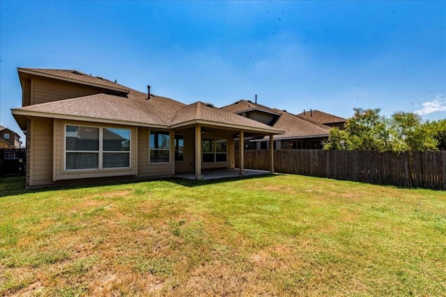 back of property with a yard, a patio area, and fence