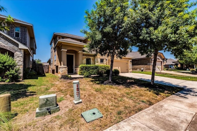 view of front facade with concrete driveway, stone siding, a front lawn, and an attached garage