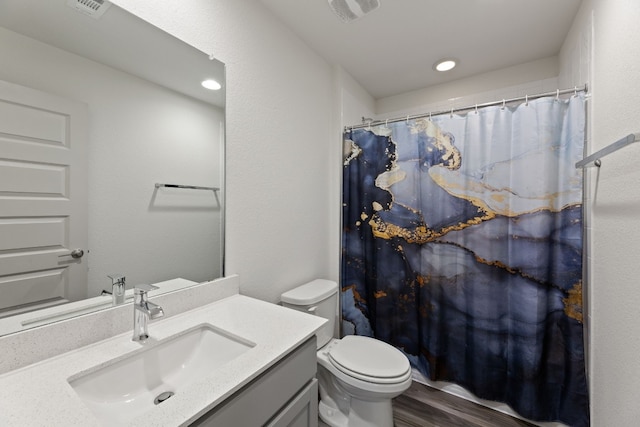 bathroom featuring toilet, vanity, hardwood / wood-style flooring, and curtained shower