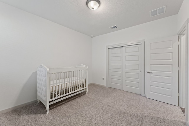 bedroom with carpet flooring, a closet, and a nursery area