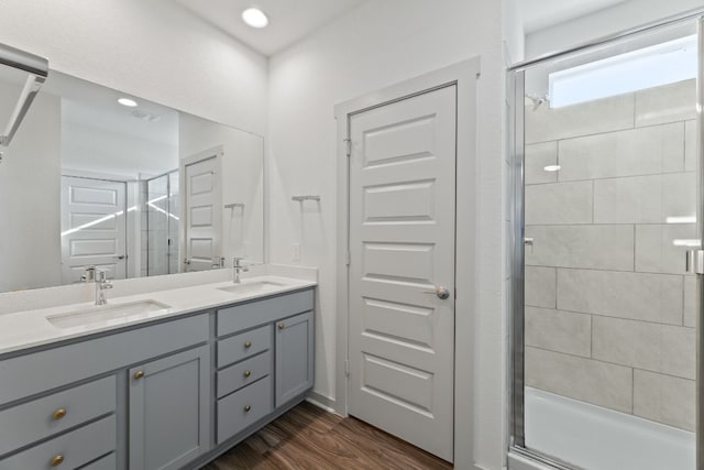 bathroom with hardwood / wood-style floors, vanity, and walk in shower