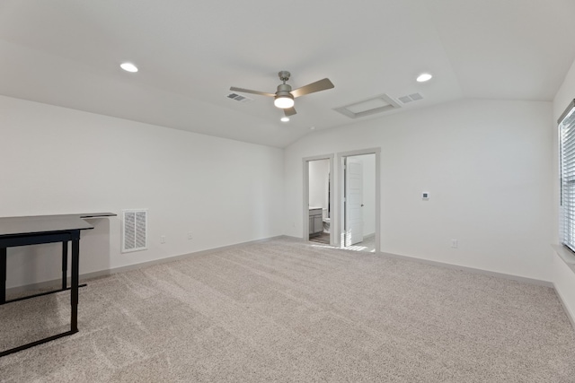 spare room featuring light colored carpet, lofted ceiling, and ceiling fan