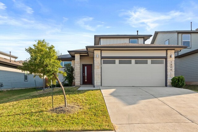 view of front of property featuring a garage and a front lawn