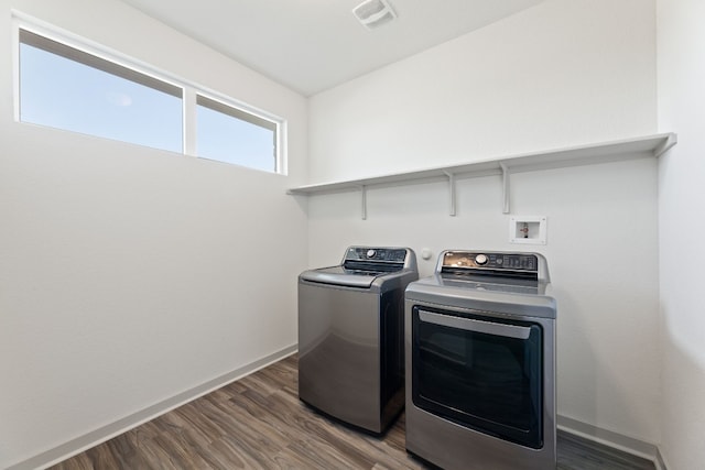 washroom featuring washing machine and dryer and dark hardwood / wood-style floors