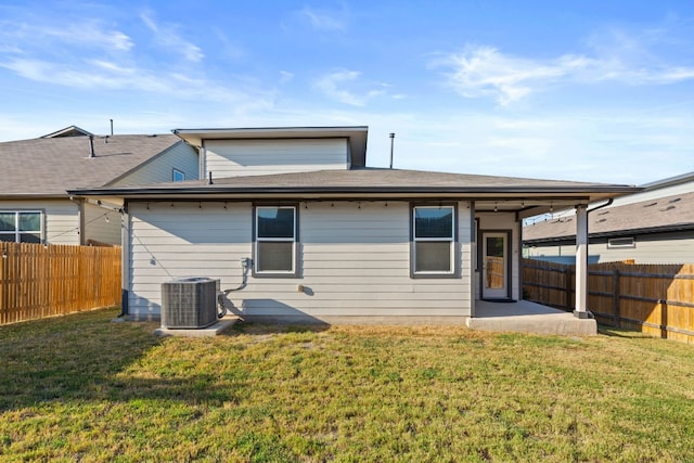 rear view of property with central AC unit, a patio, and a lawn