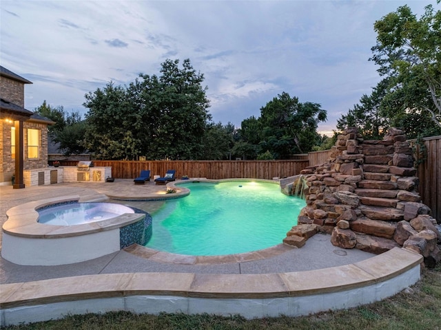 pool at dusk with an in ground hot tub and a patio area