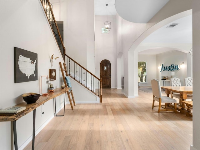 entryway featuring light hardwood / wood-style floors and a high ceiling