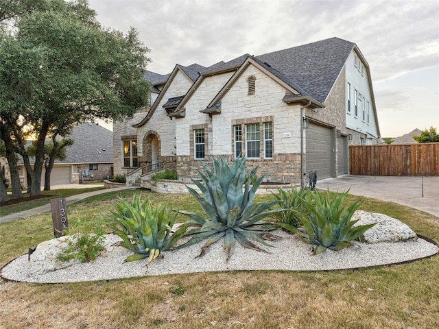 french country home featuring a front yard and a garage