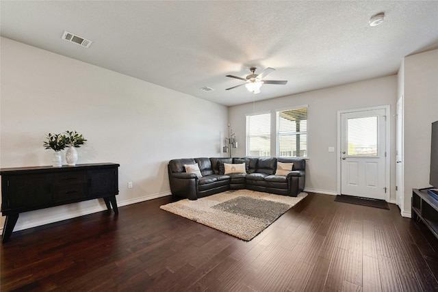 living room with ceiling fan, a textured ceiling, and wood-type flooring