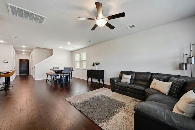 living room with dark hardwood / wood-style flooring and ceiling fan