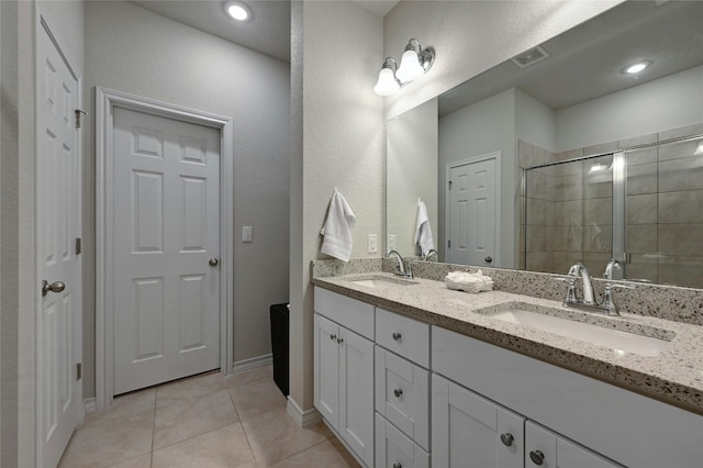 bathroom featuring tiled shower, vanity, and tile patterned floors