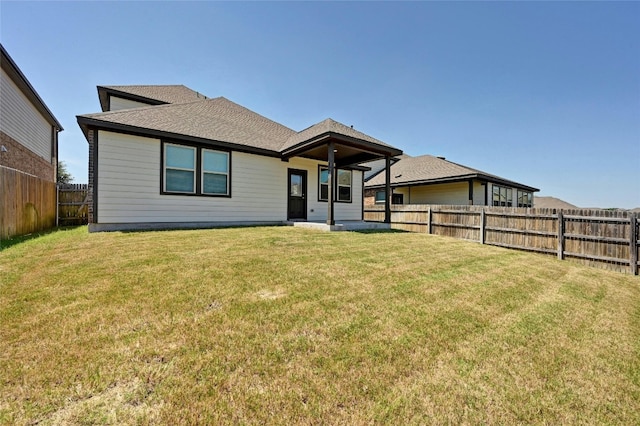 rear view of property featuring a lawn