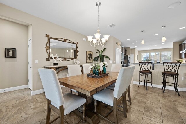 tiled dining space featuring an inviting chandelier