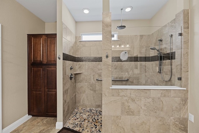 bathroom with tiled shower and tile patterned floors