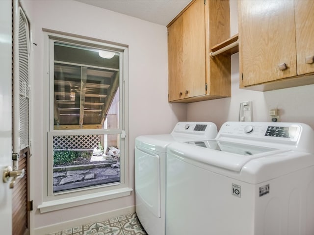 laundry room featuring washing machine and dryer, cabinets, and light tile patterned floors