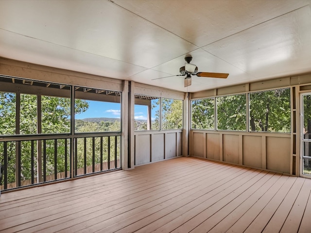 unfurnished sunroom with ceiling fan