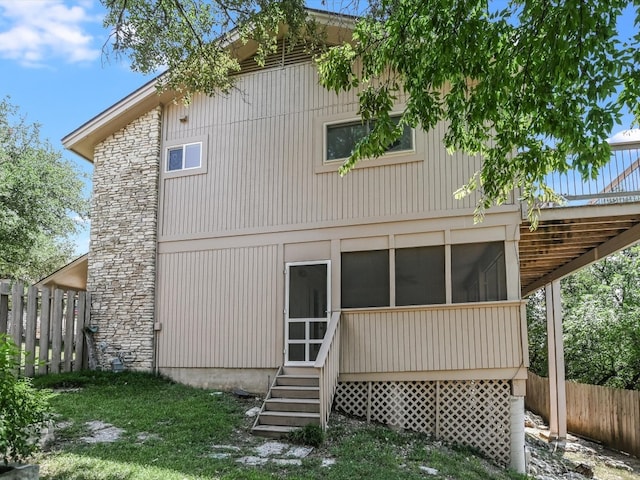 rear view of property featuring a sunroom