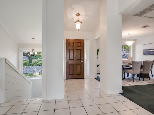 entryway featuring light tile patterned flooring and a chandelier