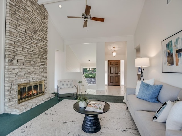 tiled living room with ceiling fan, high vaulted ceiling, a stone fireplace, and beamed ceiling