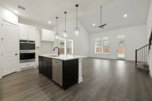 kitchen featuring sink, dark hardwood / wood-style floors, a kitchen island with sink, white cabinets, and appliances with stainless steel finishes