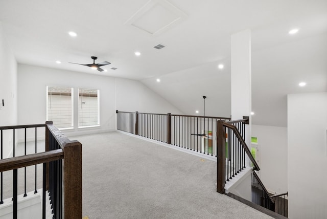 corridor featuring light colored carpet, vaulted ceiling, and a wealth of natural light