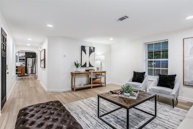 living room with hardwood / wood-style flooring and ornamental molding