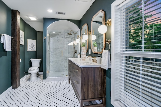 bathroom with a shower with door, vanity, and toilet