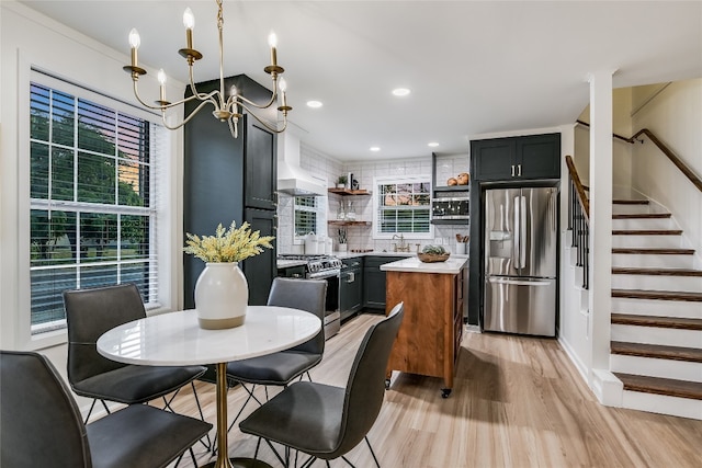 dining space with crown molding, sink, light hardwood / wood-style floors, and a notable chandelier