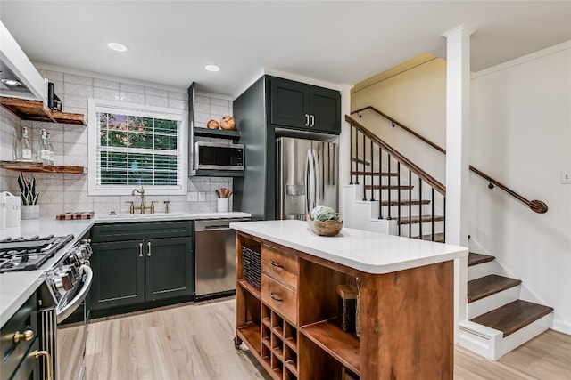 kitchen with sink, stainless steel appliances, light hardwood / wood-style floors, decorative backsplash, and a kitchen island