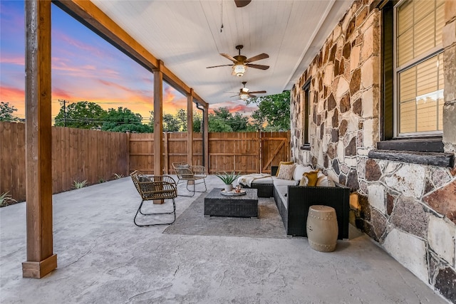 patio terrace at dusk featuring outdoor lounge area and ceiling fan