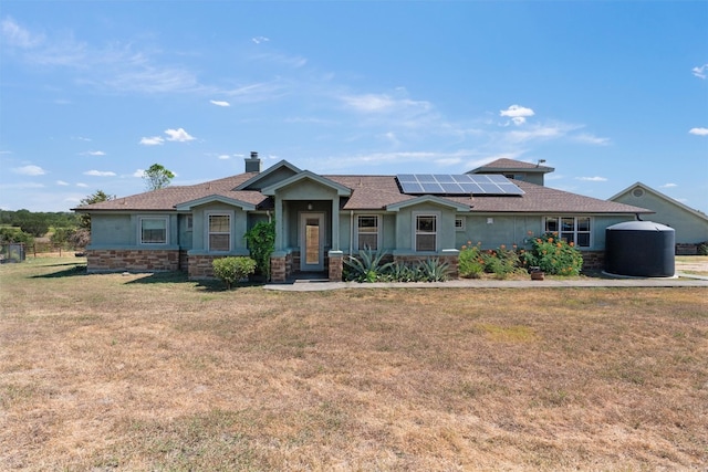 view of front facade with a front yard and solar panels