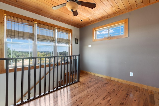 spare room with ceiling fan, hardwood / wood-style flooring, wood ceiling, and a wealth of natural light