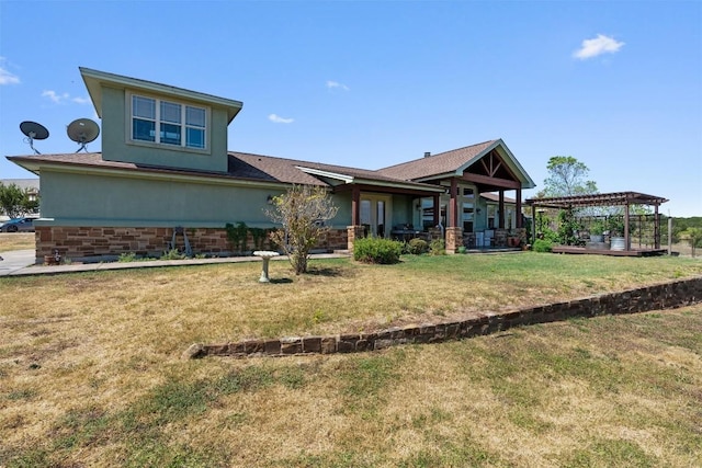 back of property featuring stucco siding, a lawn, and a pergola