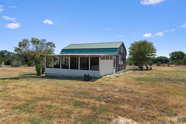 view of side of home with a rural view and a lawn