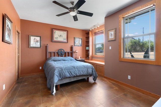 bedroom with dark tile patterned floors and ceiling fan