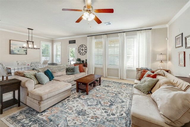 living room with ceiling fan with notable chandelier, crown molding, and light carpet