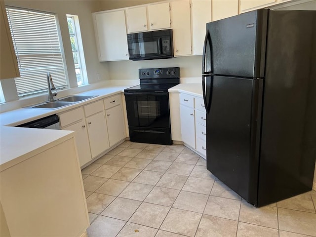 kitchen with light tile patterned floors, light countertops, black appliances, white cabinetry, and a sink