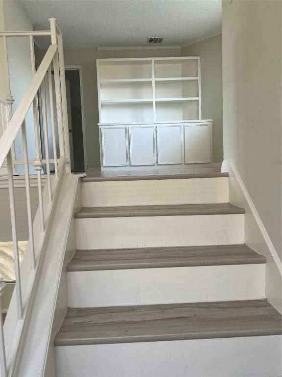 stairway with a textured ceiling