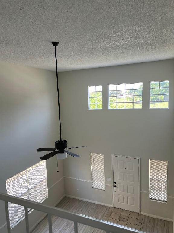 details with a textured ceiling, wood finished floors, a ceiling fan, and baseboards